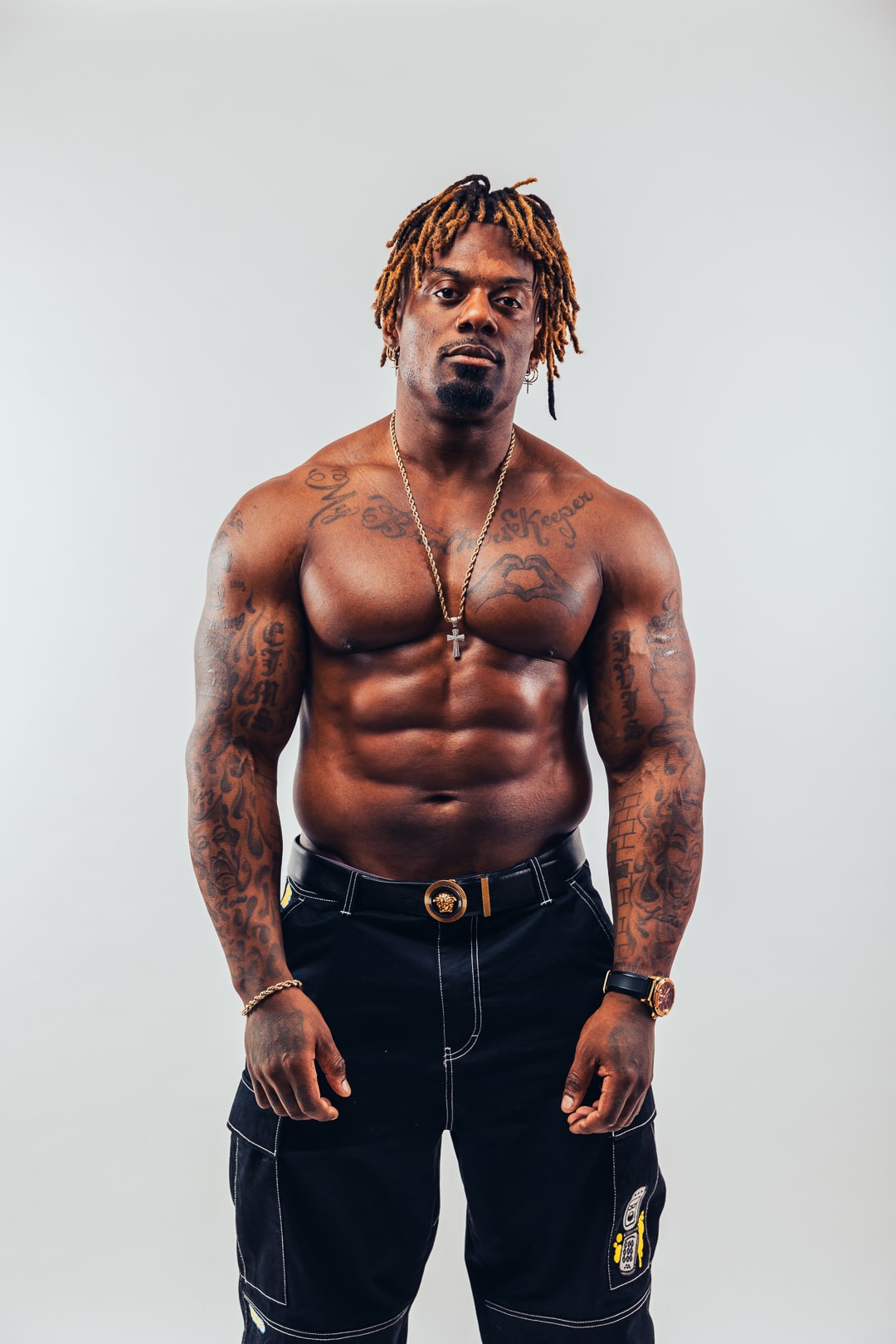 Dat Boi Jonni studio portrait, shirtless, gold cross chain, direct gaze